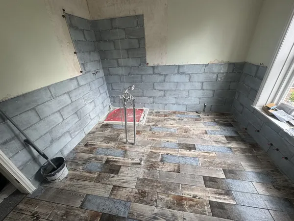 Professional tiling tools and laser level setup during a bathroom renovation in Hull